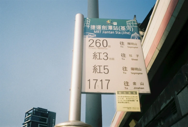 a sign pointing up and a pole with a building in the background