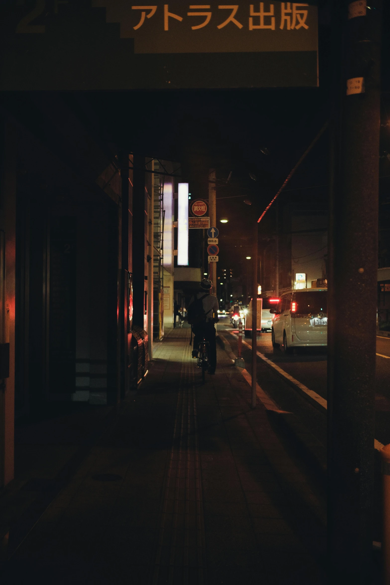 a dark street with a car and buses on it