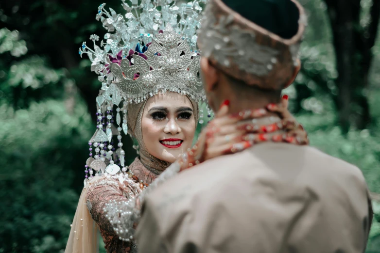 a woman in a headpiece talking to a man