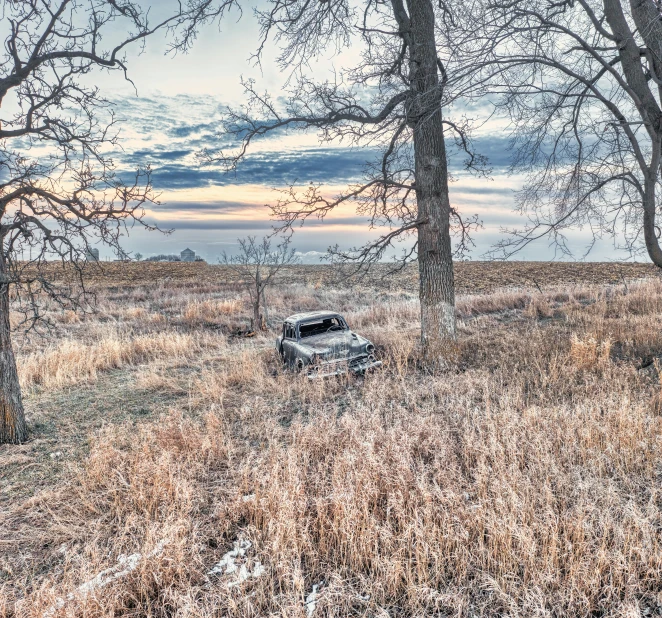 the old vehicle is in the middle of the dry field