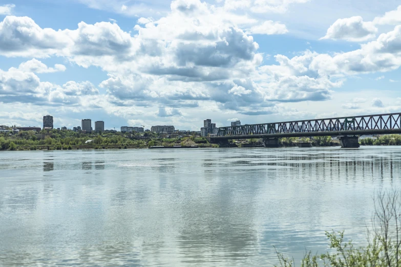 a large bridge spanning across the water near a city