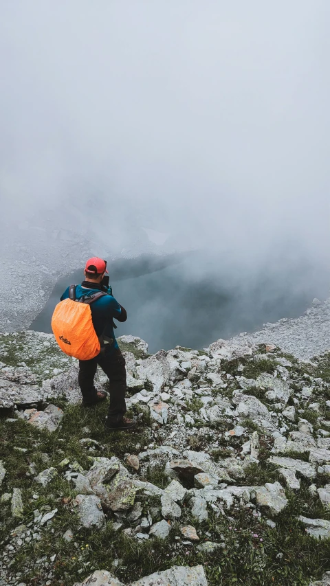 a person is standing on a hill, with some fog in the distance