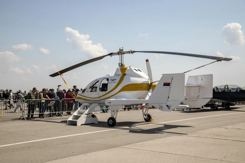 a white and yellow helicopter sitting on top of an airport runway