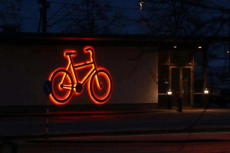 a neon bike sign on the side of the road