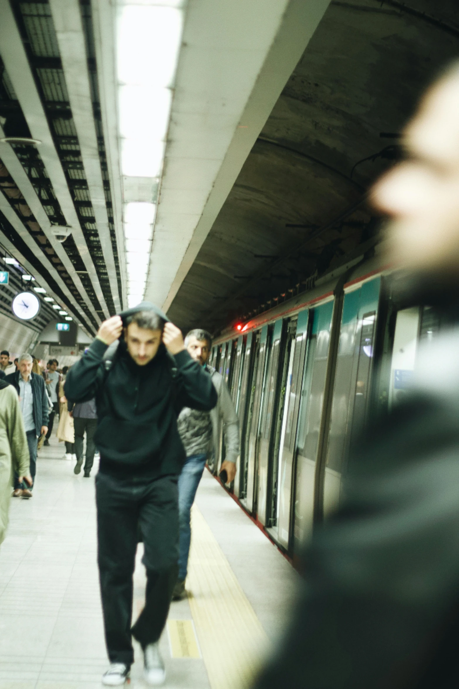 people are walking and riding trains in the station