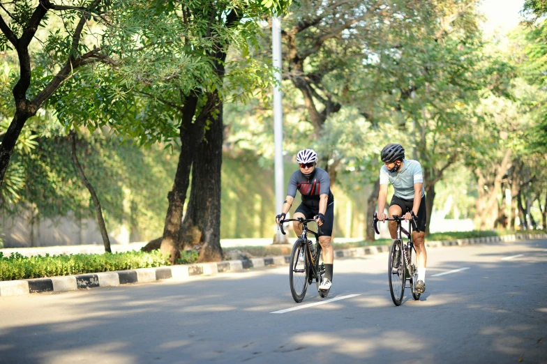 two people riding bicycles down a curvy road