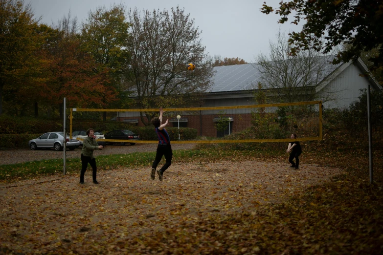 three men playing soccer on an out - back yard