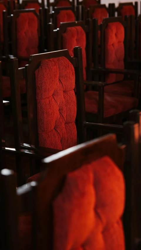 rows of red seats sit in the middle of a large auditorium