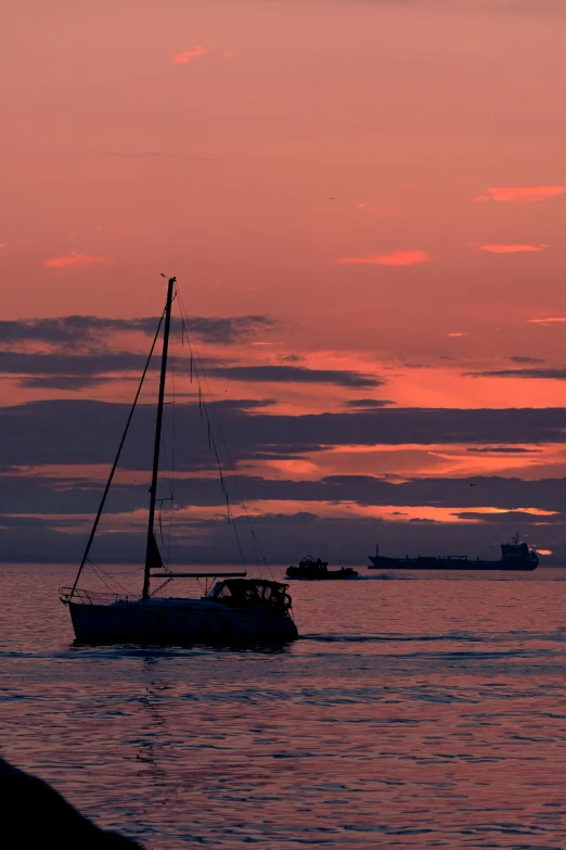 a boat sailing on the water at sunset