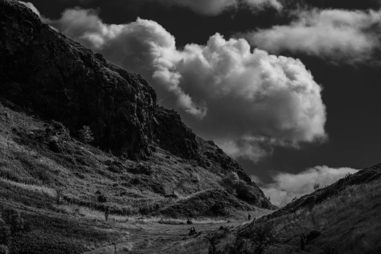 two people walking up a rocky mountain road