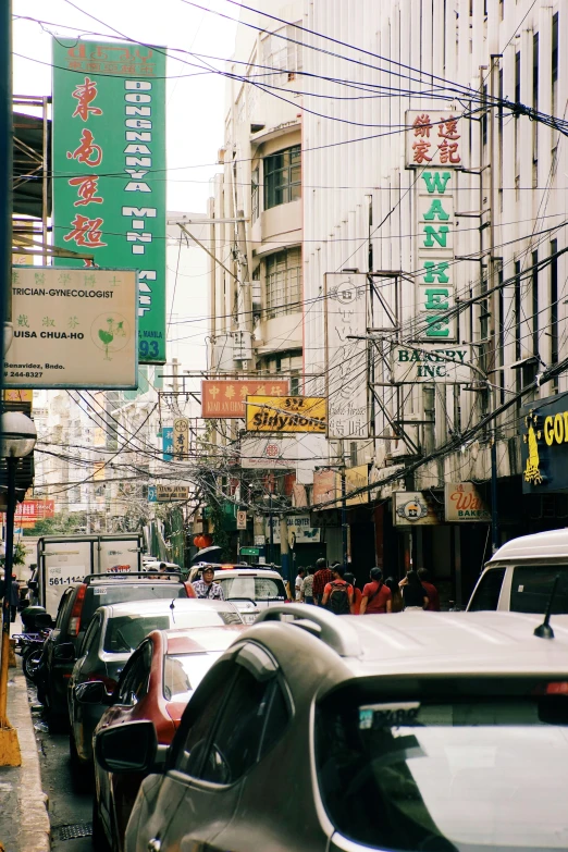 an asian street with some cars and signs