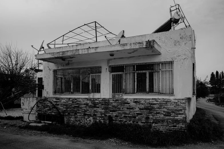 a black and white po of an abandoned building with a roof in a village