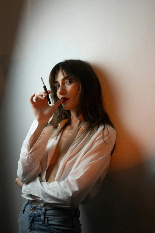 a beautiful young woman smoking a cigarette standing