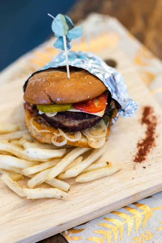 a cheeseburger with french fries on a wooden board