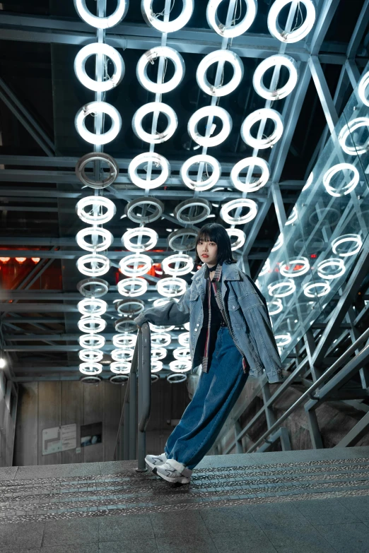 the model is standing in front of suspended lights