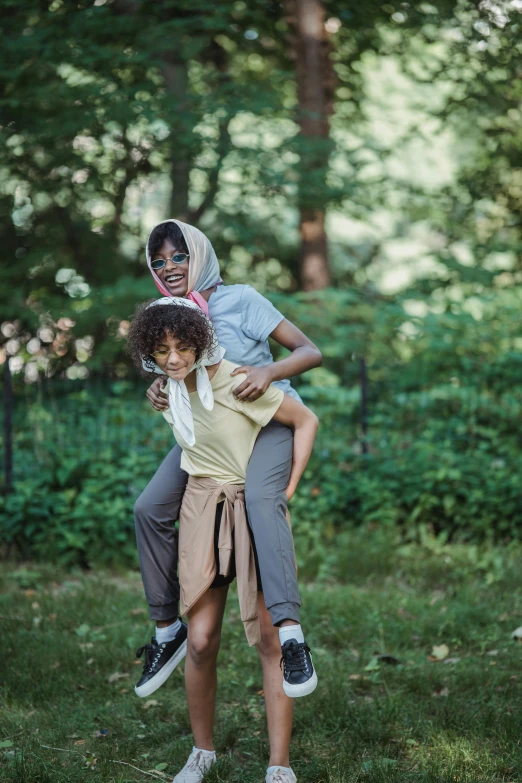 a girl holding her friend in the air while smiling