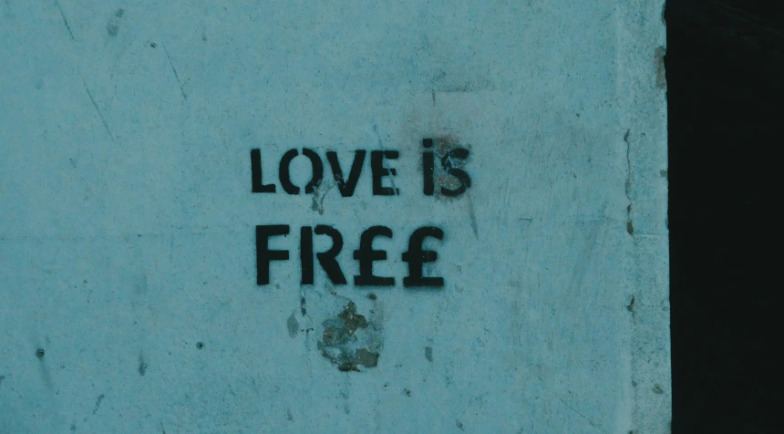 graffiti on the corner of a wall with a free sign