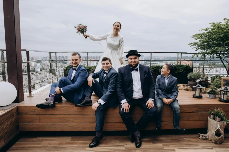 three people, one of them is sitting down with the other four are dressed up