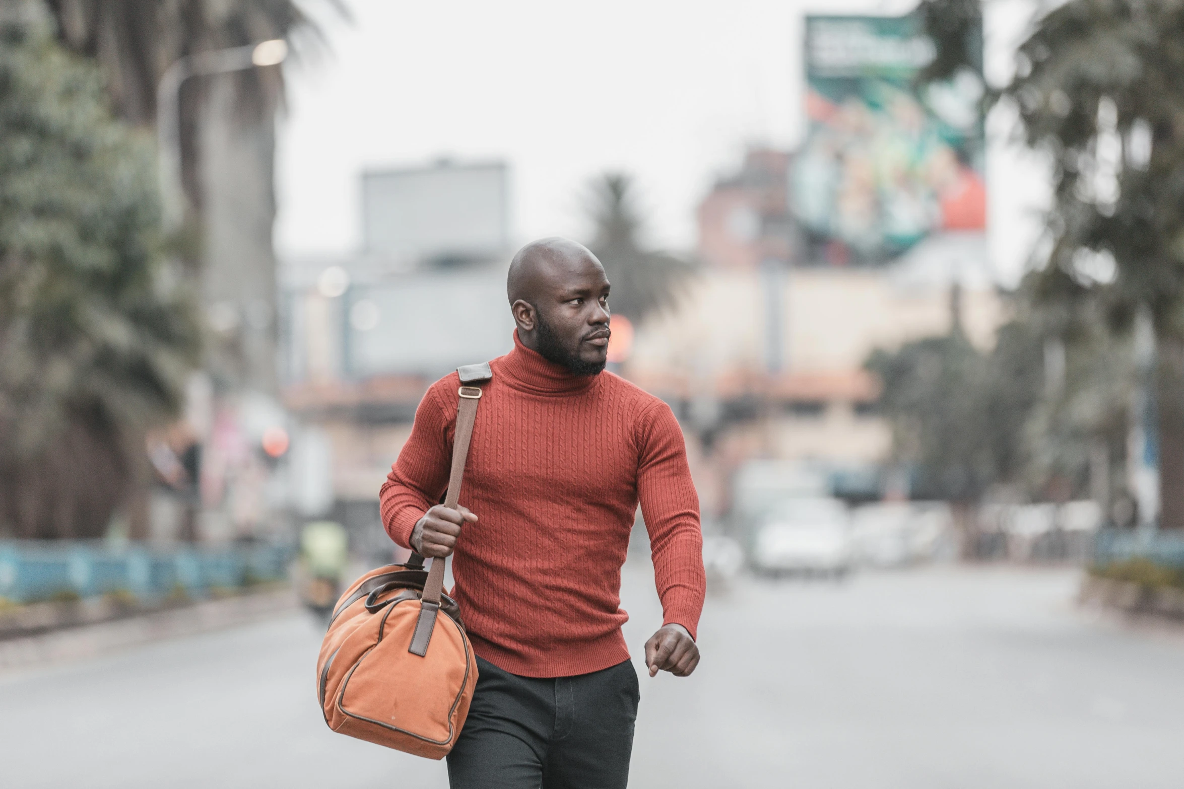 a man walking on a street holding a bag in one hand