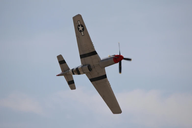 this is an old fashioned propeller plane flying in the sky