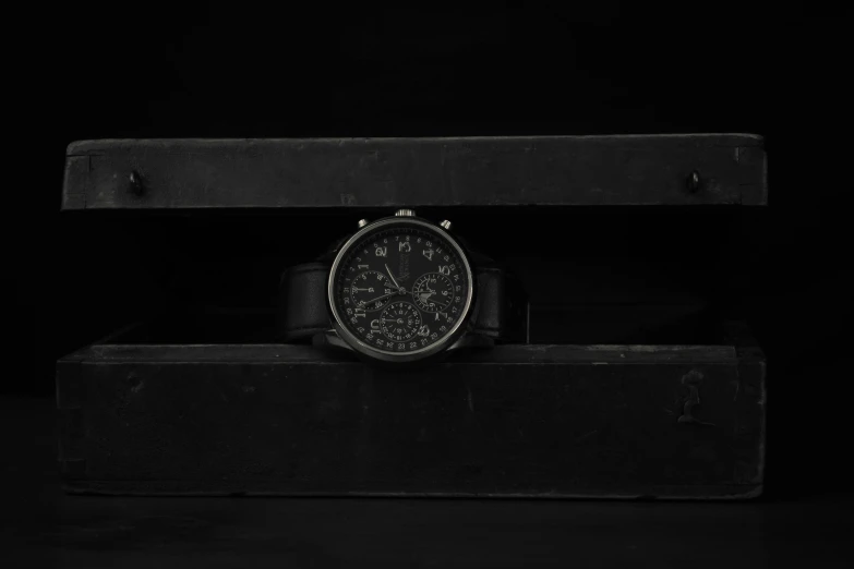 an old watch sits on display with a black background