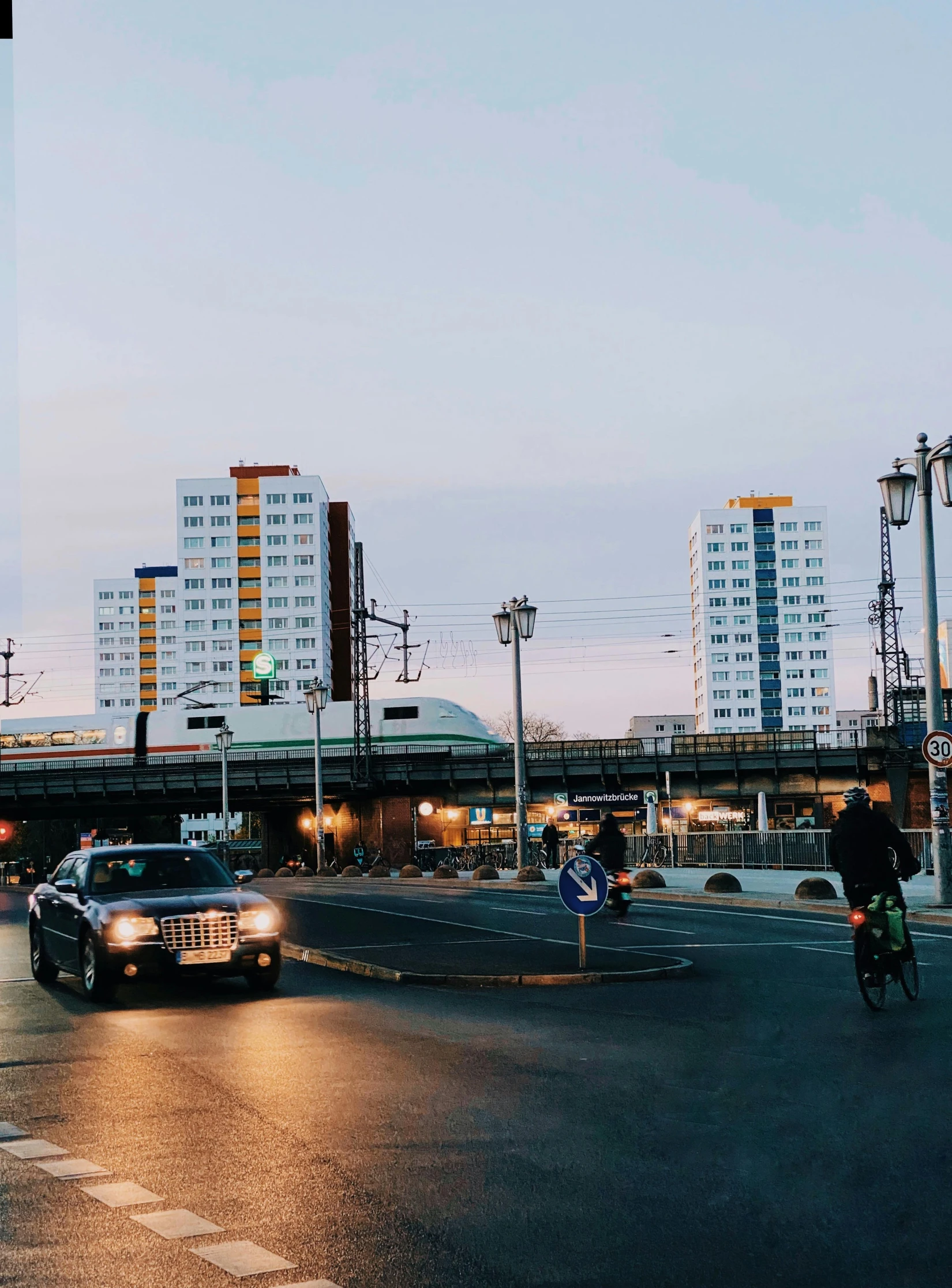 a black car driving through a traffic filled intersection