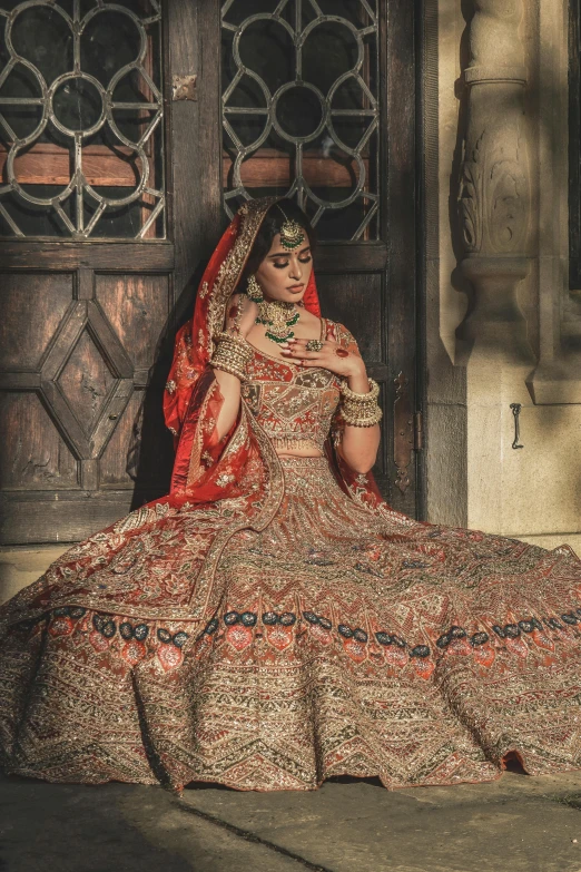 a woman sitting down wearing a bridal dress