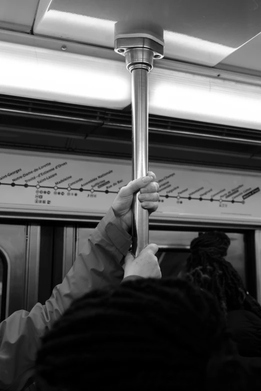 people are on the train and there is one holding a pole