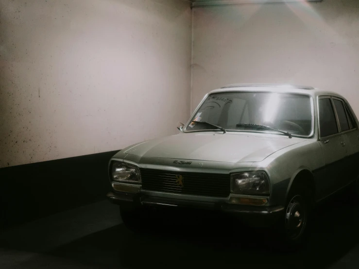 an old car sits in the middle of a empty room