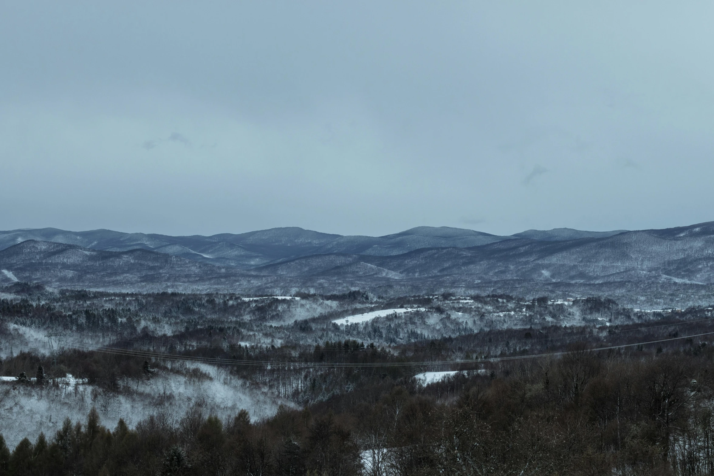 a hill filled with snow covered hills surrounded by trees