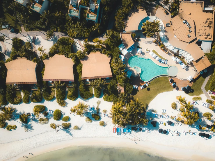 an aerial view of several pools, sand and some trees