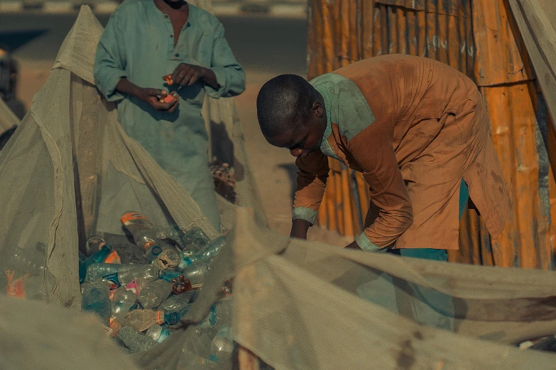 two men work together to sort plastic bottles