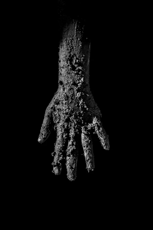a dark hand is outstretched, covered in some small bits