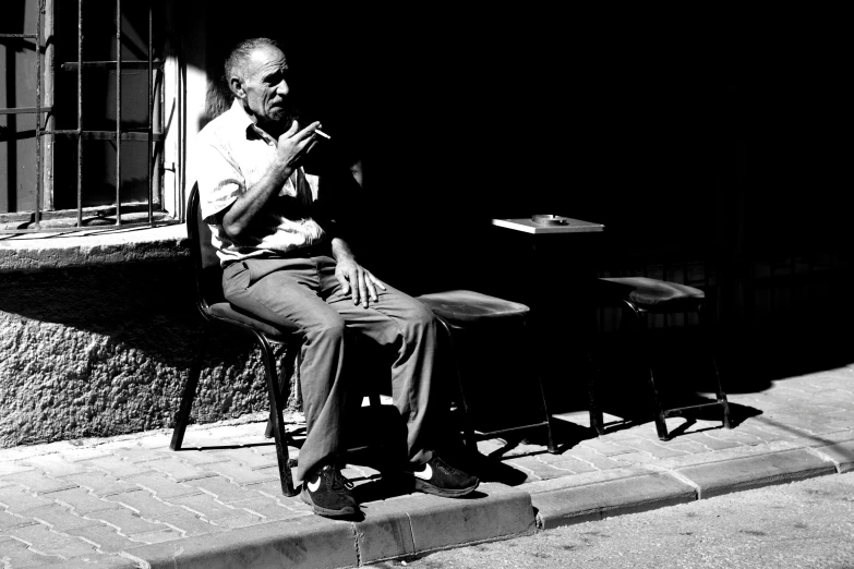 a man sits on a chair while smoking