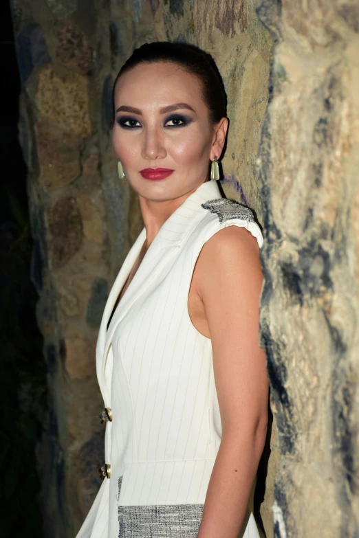 a woman wearing white and wearing large earrings