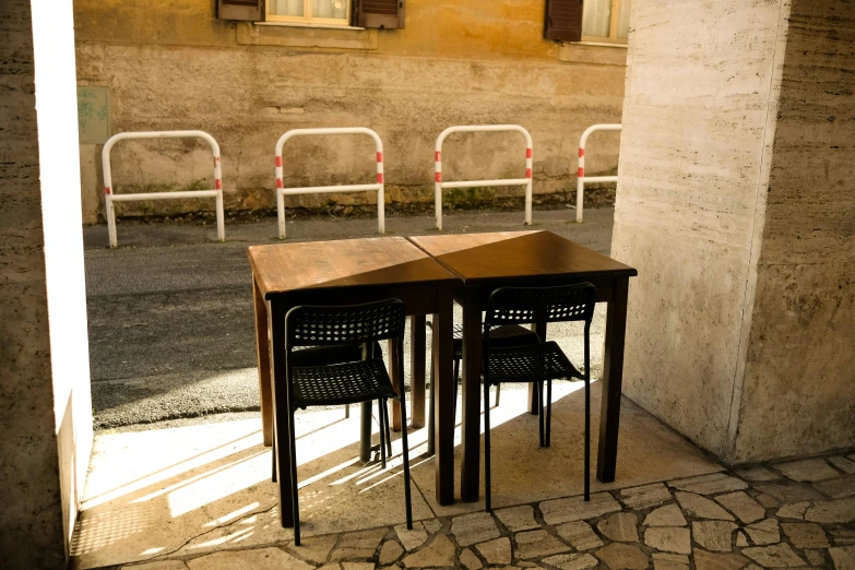 three empty chairs and two small table next to the wall