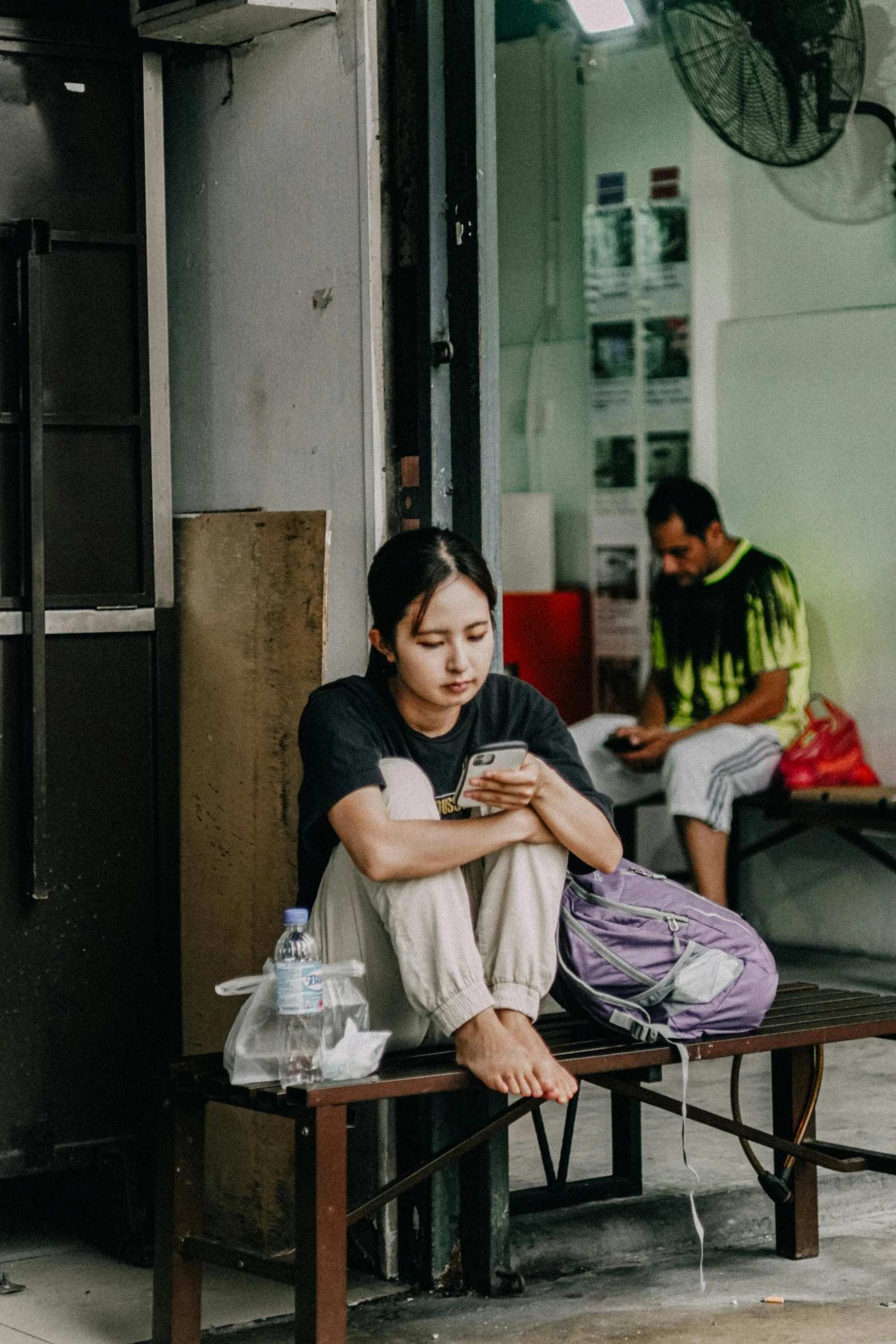 a woman sits at a table looking at her phone