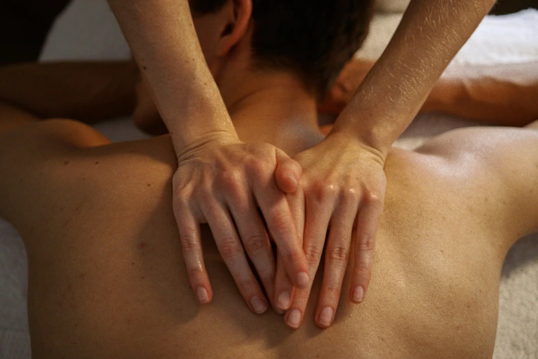 an image of a man receiving back massage from another