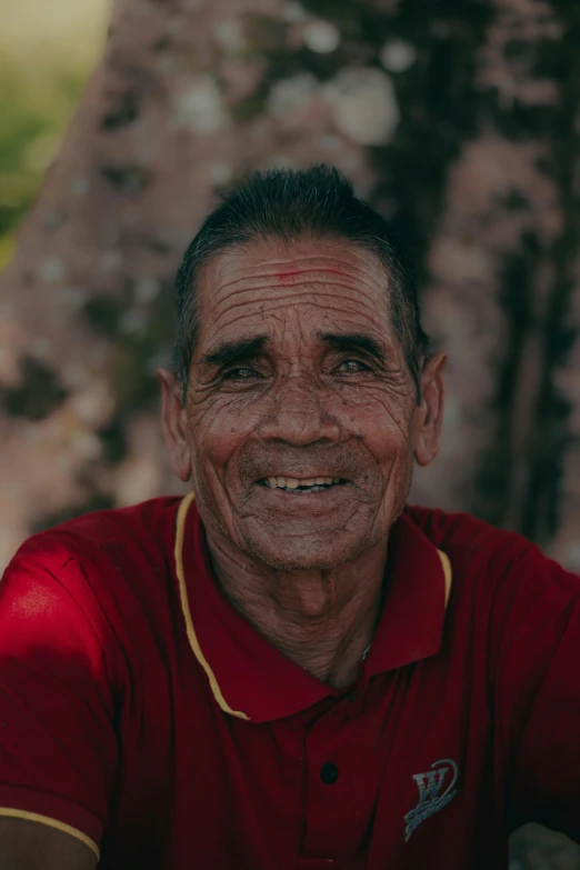 a man in a red shirt with white spots on his face