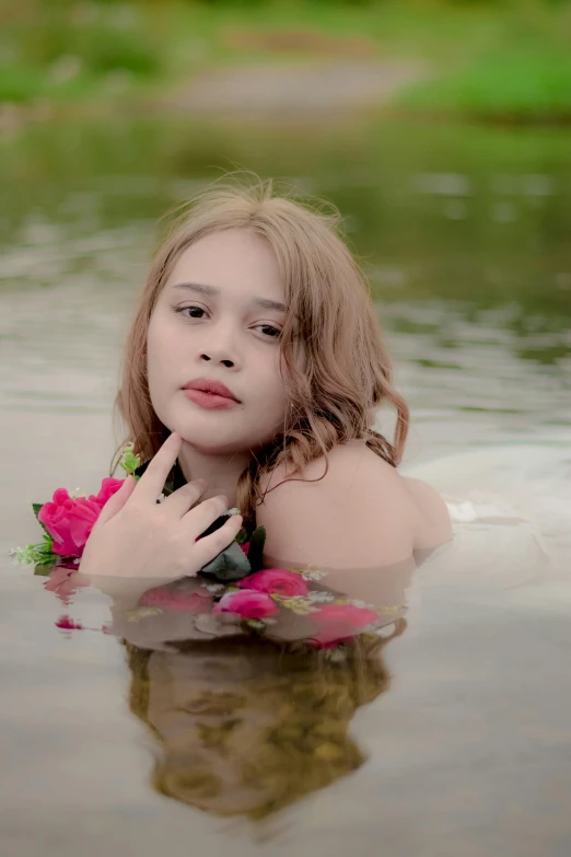 a young woman in the water holding a flower