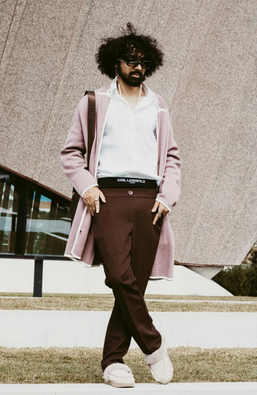 a man with glasses is walking around in front of a building