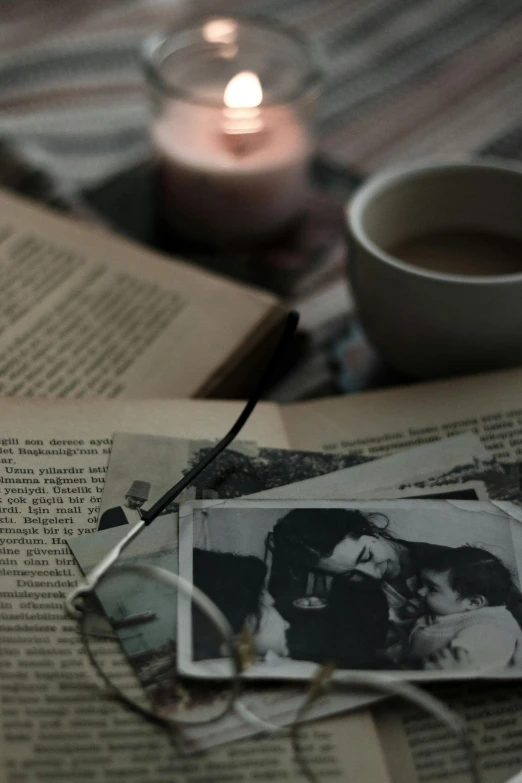 a coffee cup and an old book on a bed