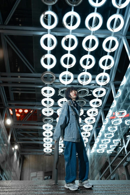 a model poses on some steps that feature circles of lights