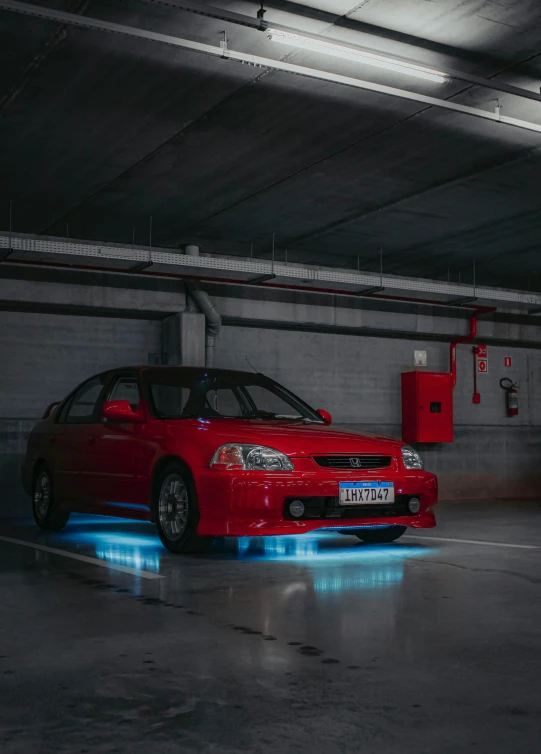 a car in a parking garage with light on the floor