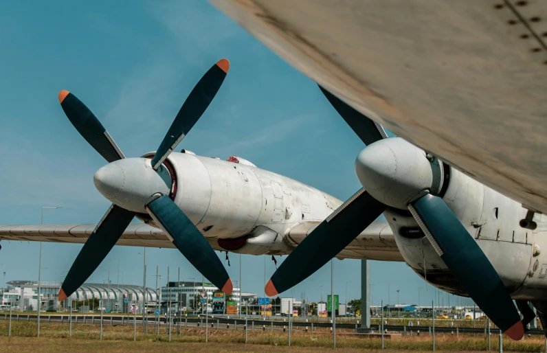 an airplane with propellers sitting next to another plane