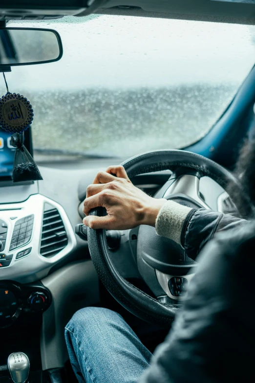 a woman driving a car while holding the steering wheel