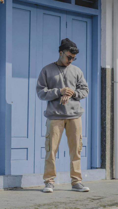 a young man standing in front of a blue door