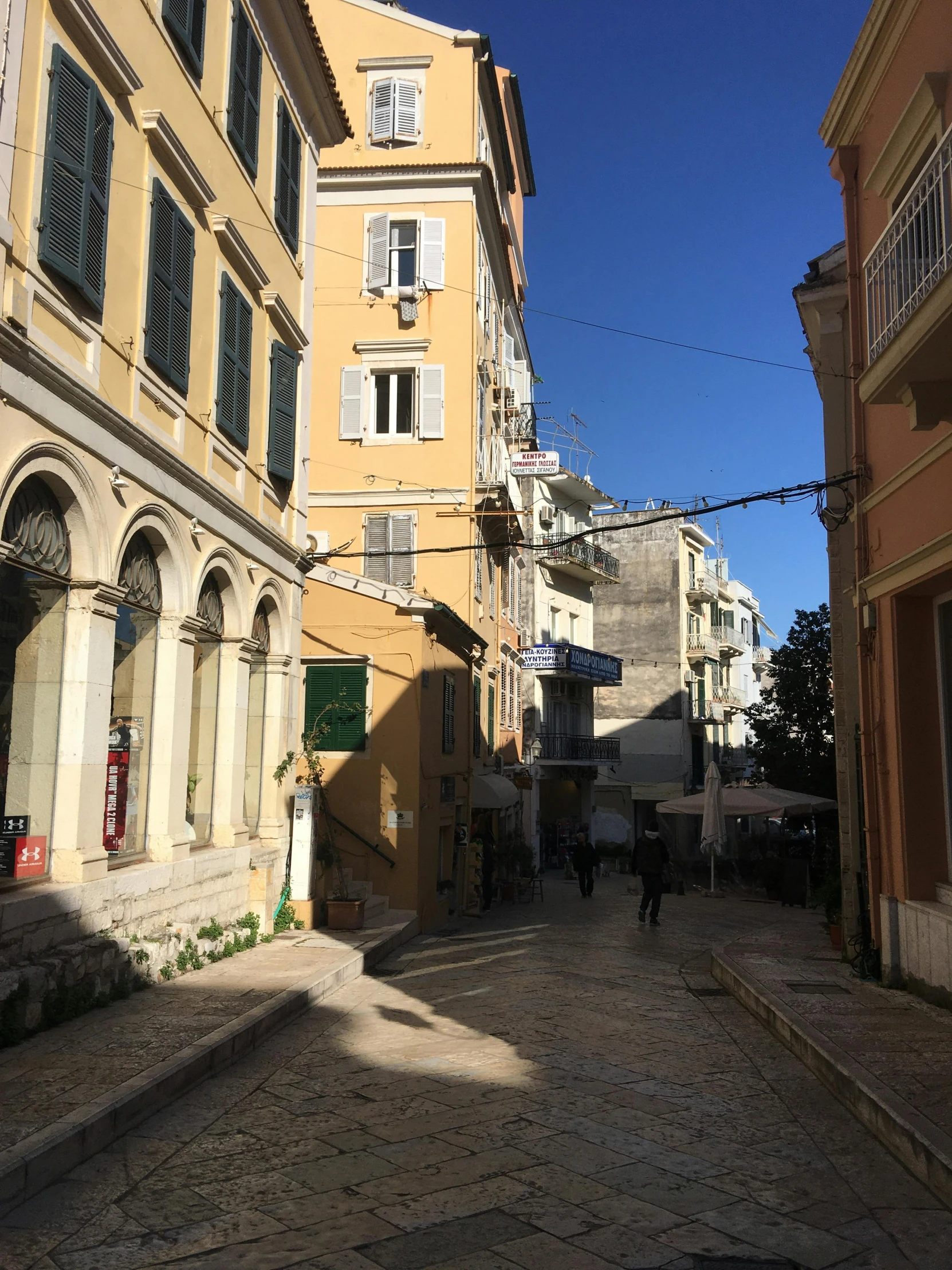 people walking down a small cobbled stone road in an old town