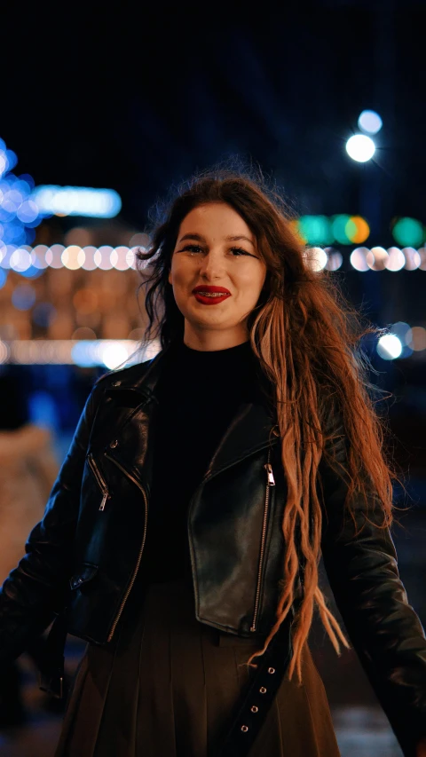 a beautiful woman in a black top and leather jacket