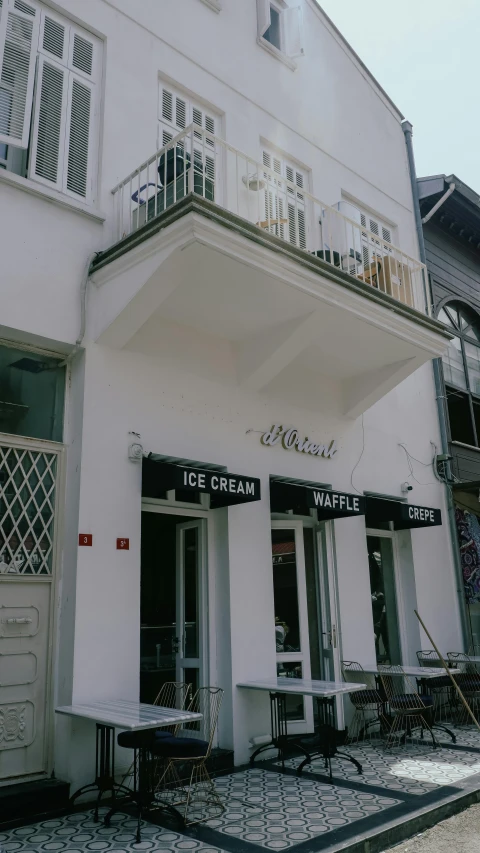 a building with a few small tables and chairs outside it